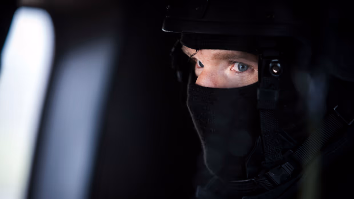 Marechaussee met een balaclava op. 