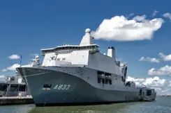 Wit schip met grijze onderkant ligt aan de haven.