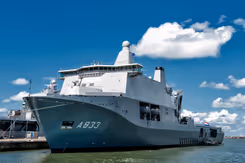 Wit schip met grijze onderkant ligt aan de haven.