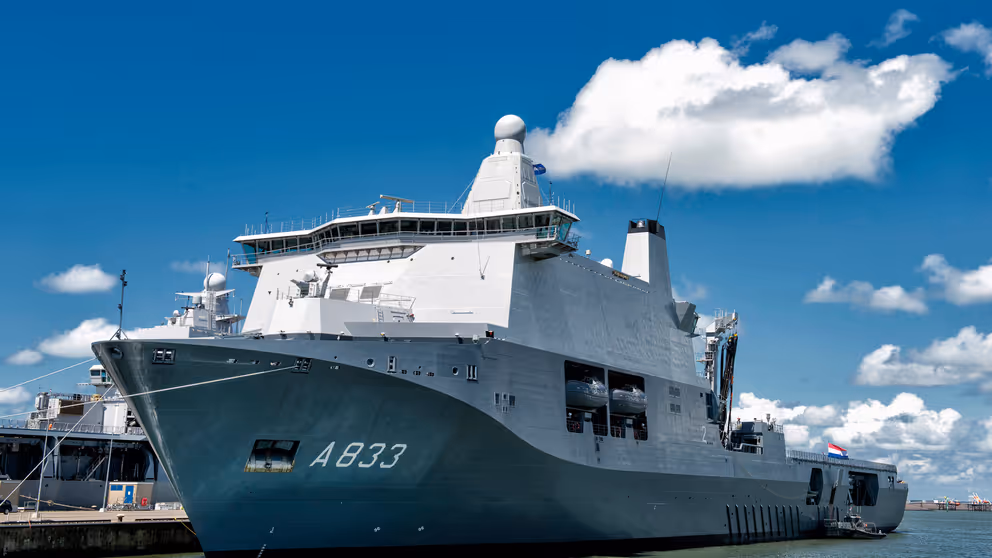 Wit schip met grijze onderkant ligt aan de haven.