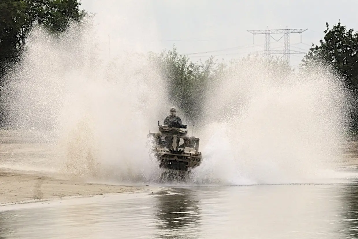 Water spat meters hoog op als een Vector door het water van een vijver rijdt.