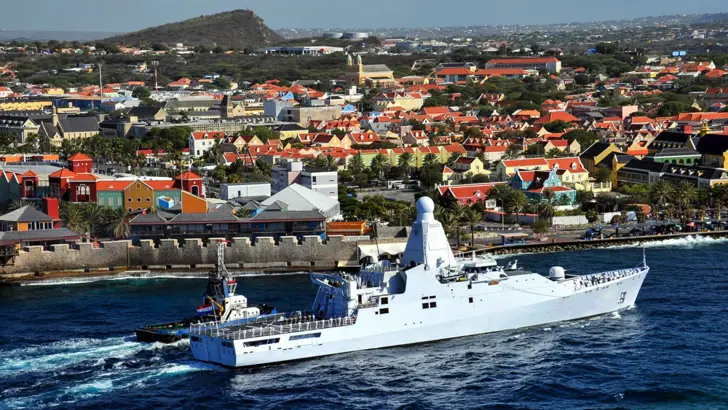 Patrouilleschip Zr.Ms. Holland vaart langs de kade in Curaçao.