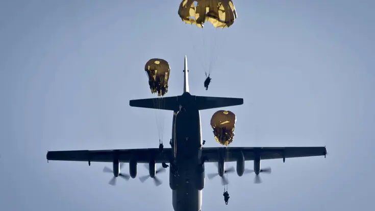 Gezien vanaf de grond: paratroepen van 11 Luchtmobiele Brigade springen uit een Hercules C-130 transportvliegtuig.