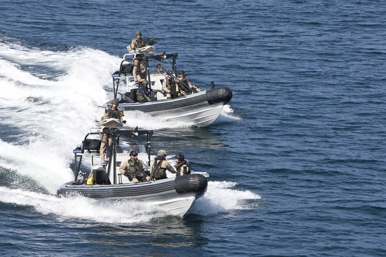 Een boardingteam in 2 RHIB's. In de achterste RHIB is een boardingladder te zien.