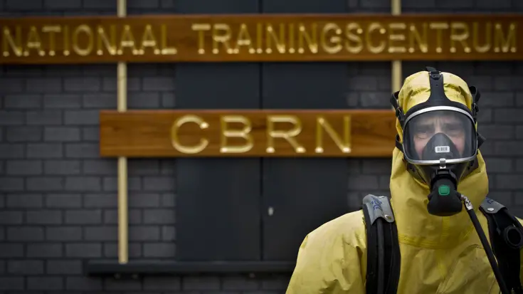 CBRN-specialist met beschermde kleding voor het Nationaal Trainingscentrum CBRN.