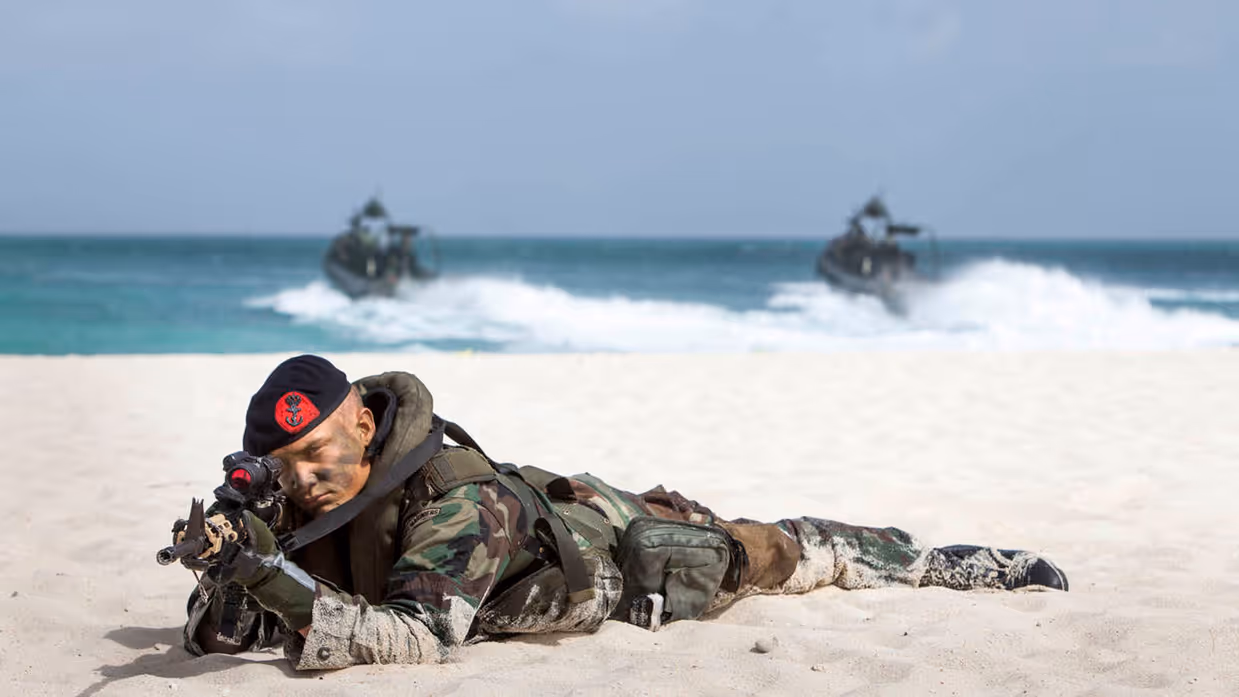 Een marinier liggend op zijn buik in het oude uniform op het strand van Sint-Maarten.