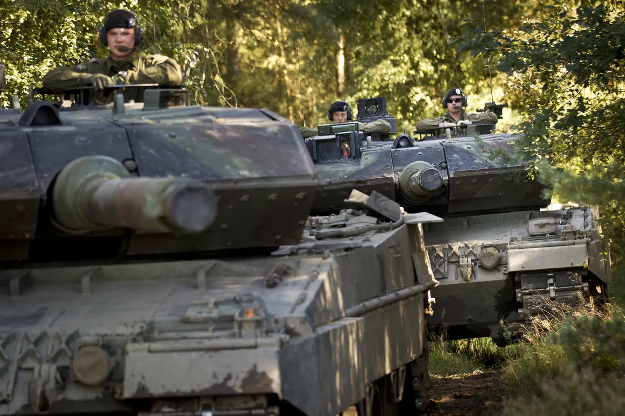 2 Leopard-gevechtstanks rijden achter elkaar in een bos.