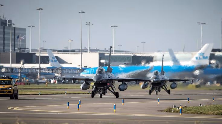 F-16's van de voorzijde gezien met blauwe KLM-toestellen op de achtergrond.