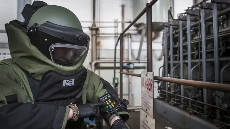 Een explosieven ruimer bedient het communicatiepaneltje op de mouw van het zware bommenpak tijdens oefening Lowlands Grenade (Duitsland, 2016).