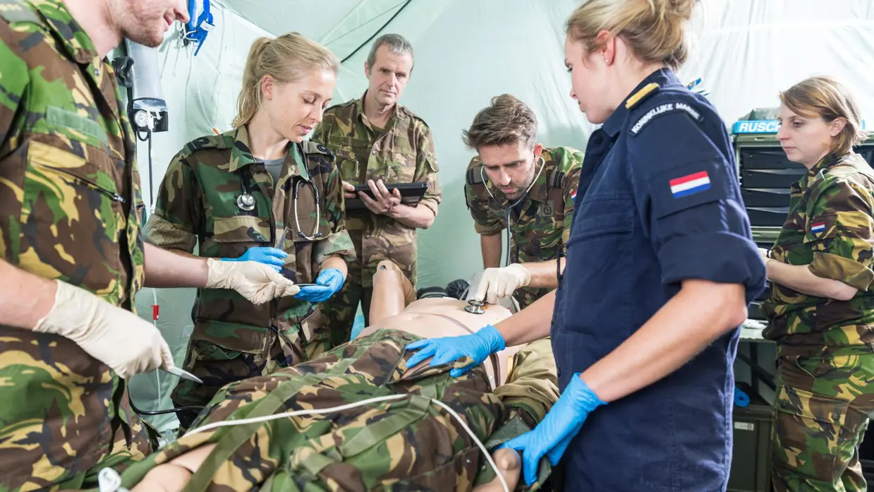 Militairen van de geneeskundige diensten staan rond een lotusslachtoffer.