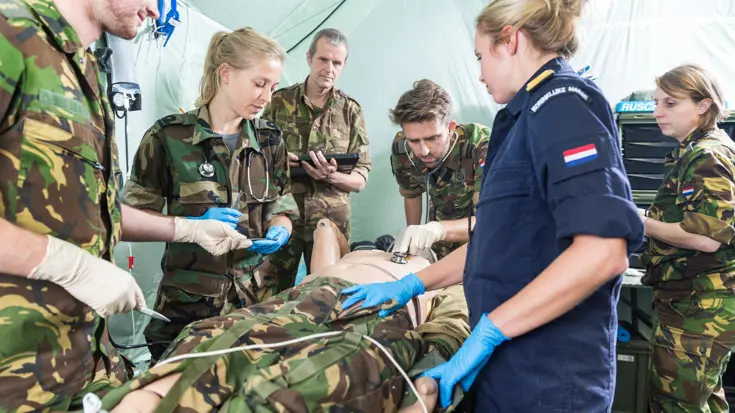 Militairen van de geneeskundige diensten staan rond een lotusslachtoffer.
