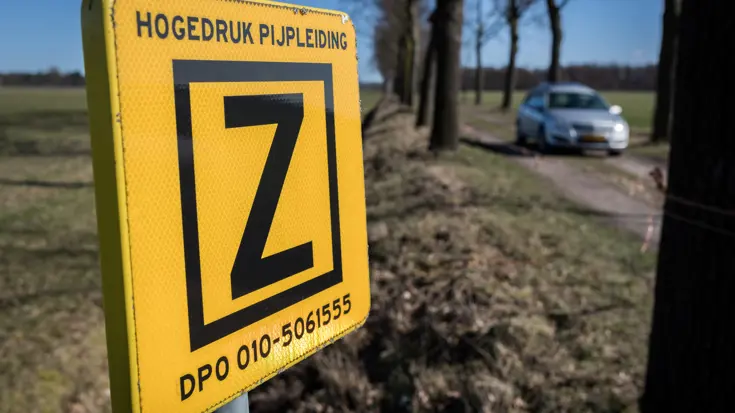 Waarschuwingsbord ligging hogedruk pijpleiding. Tekst op bord: hogedruk pijpleiding Z DPO 010-5061555.
