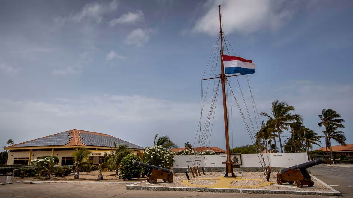 Overzicht over Marinierskazerne Savaneta vanaf zee, met op de voorgrond een Kustwacht-cutter.