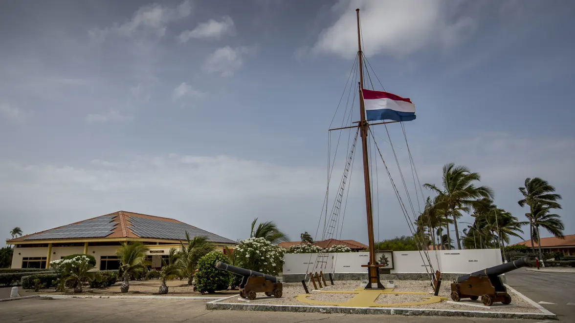 Overzicht over Marinierskazerne Savaneta vanaf zee, met op de voorgrond een Kustwacht-cutter.