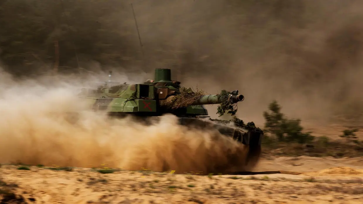 Rijdende CV-90 in stofwolk in Litouwen.