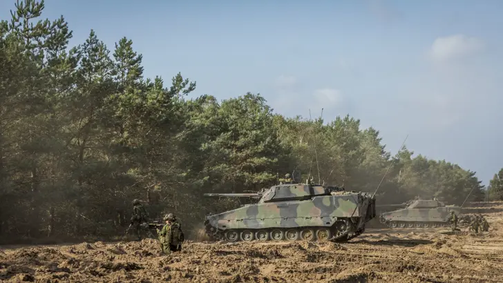 2 CV90's en zogenoemde uitgestegen infanteristen staan langs de bosrand tijdens een oefening op de Leusderheide (september 2018).
