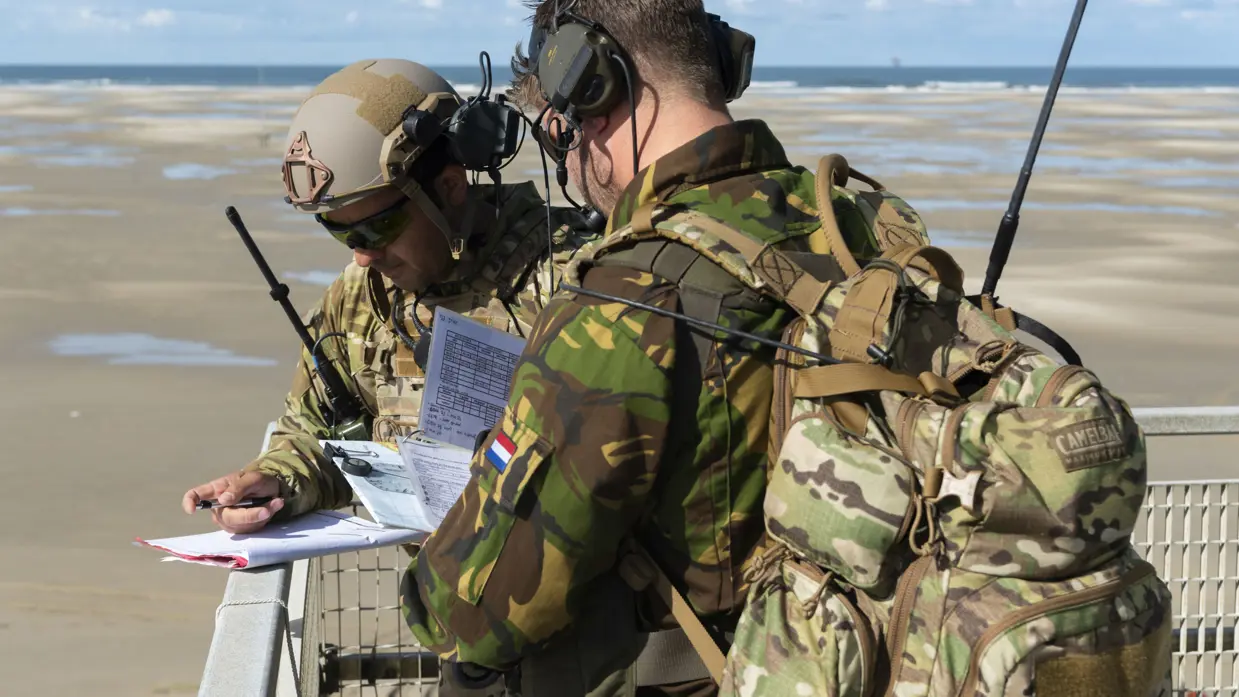 2 militairen meten het geluid tijdens een oefening op Vliehors Range.