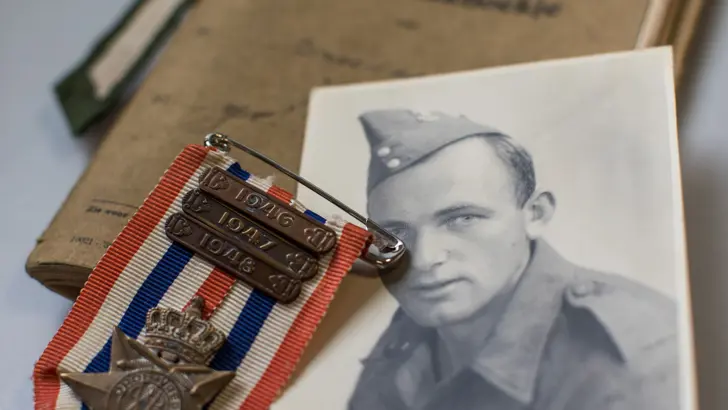 Ereteken voor Orde en Vrede met jaargespen van ’46, ’47, ’48, portretfoto opa Niels, Oorlogszakboekje en soldatenstreep.