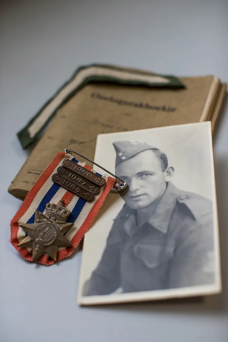 Ereteken voor Orde en Vrede met jaargespen van ’46, ’47, ’48, portretfoto opa Niels, Oorlogszakboekje en soldatenstreep.