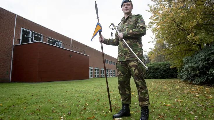 Militair met oude speer en officierssabel.
