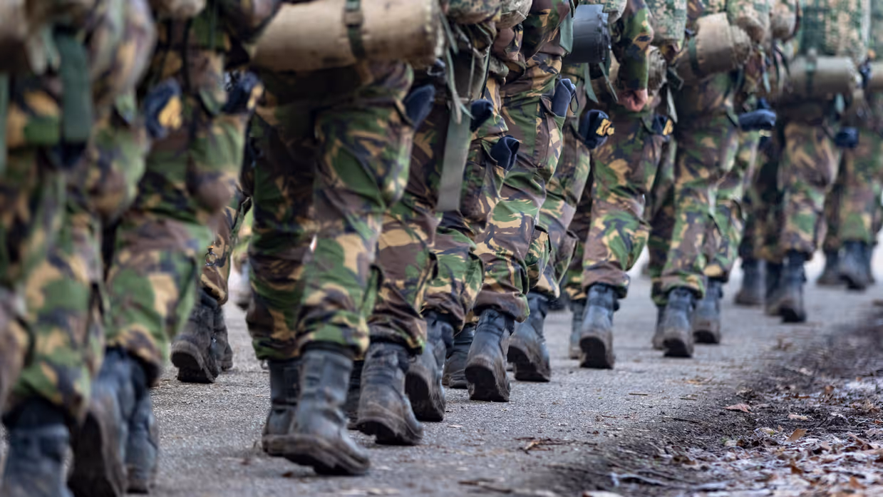 Close-up van benen van een marcherende groep militairen.