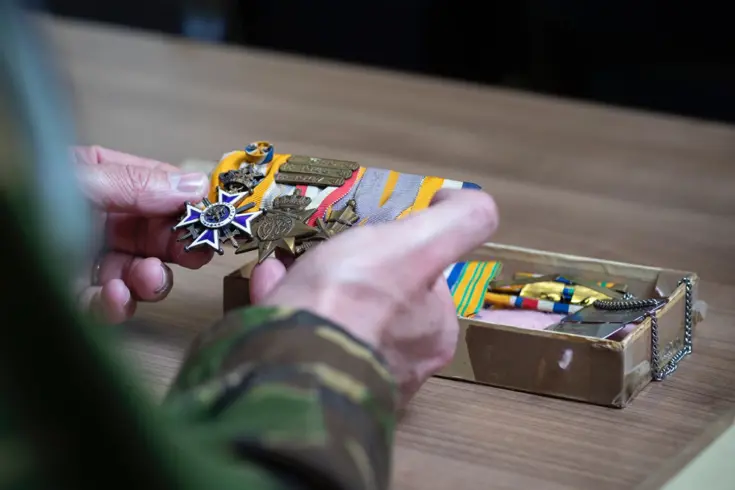 Medailles oud-militair in hand van militair.