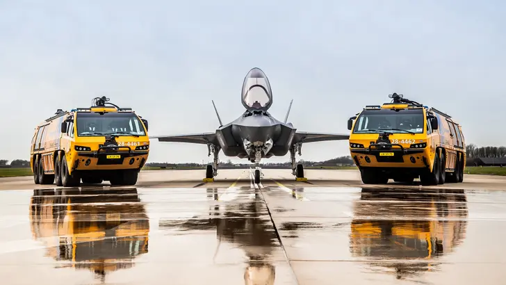 2 gele brandweerwagens met in het midden een F-35.