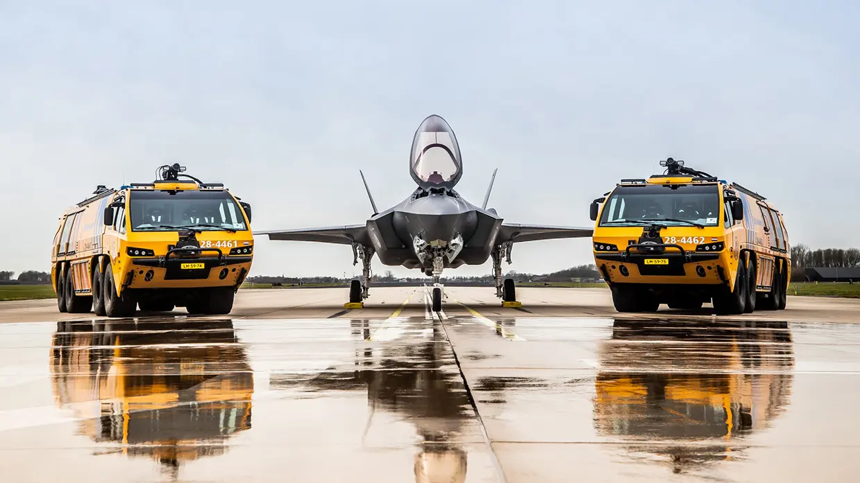 2 gele brandweerwagens met in het midden een F-35.