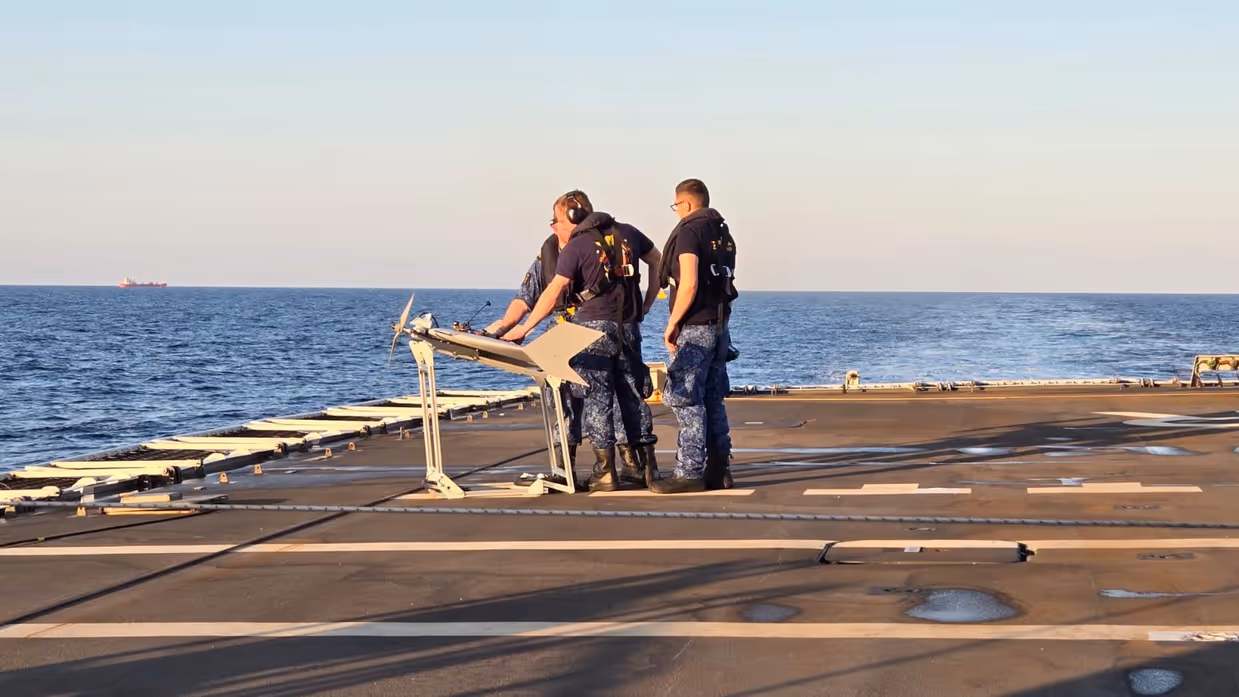 Een droneteam staat op het punt om een drone vanaf het helidek te lanceren.