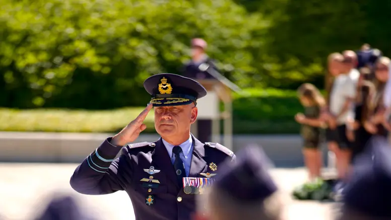 Luitenant-generaal André Steur salueert naar aan aantal militairen die wazig in de voorgrond te zien zijn.