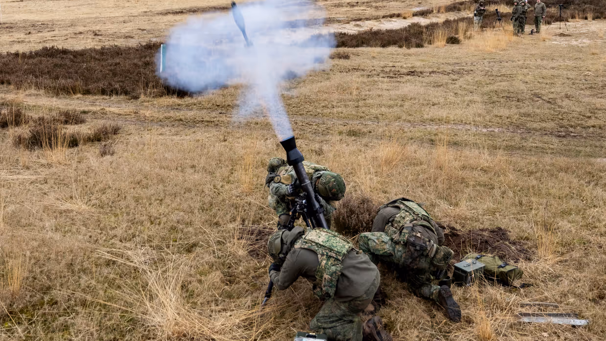 Militairen vuren al liggend op de buik mortieren af.