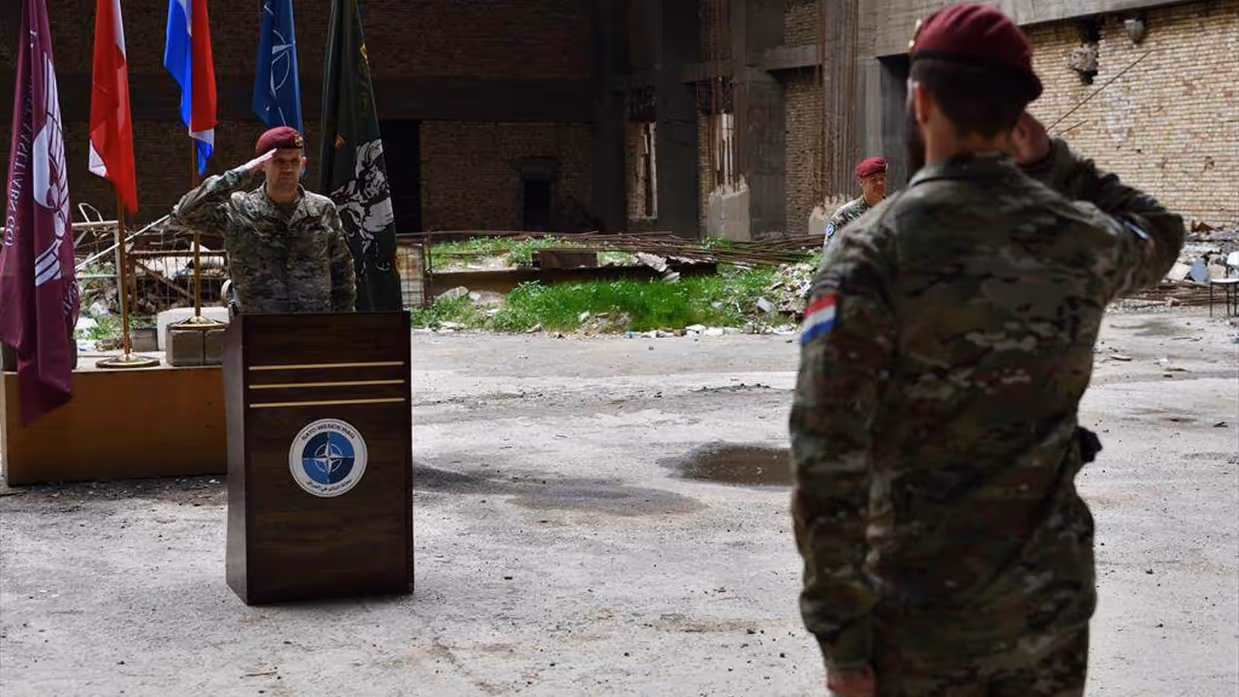 Twee militairen staan tegenover elkaar en salueren.