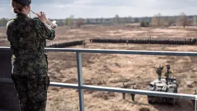 Mix van beelden van Delano. We zien onder meer zijn kist gedragen door militairen, een groepsappel met trompet en een herdenkingsplek voor de gevallen militair.&nbsp;