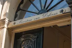 Bovenzijde van historische deur met de tekst Ministerie van Defensie op de deurstijl.