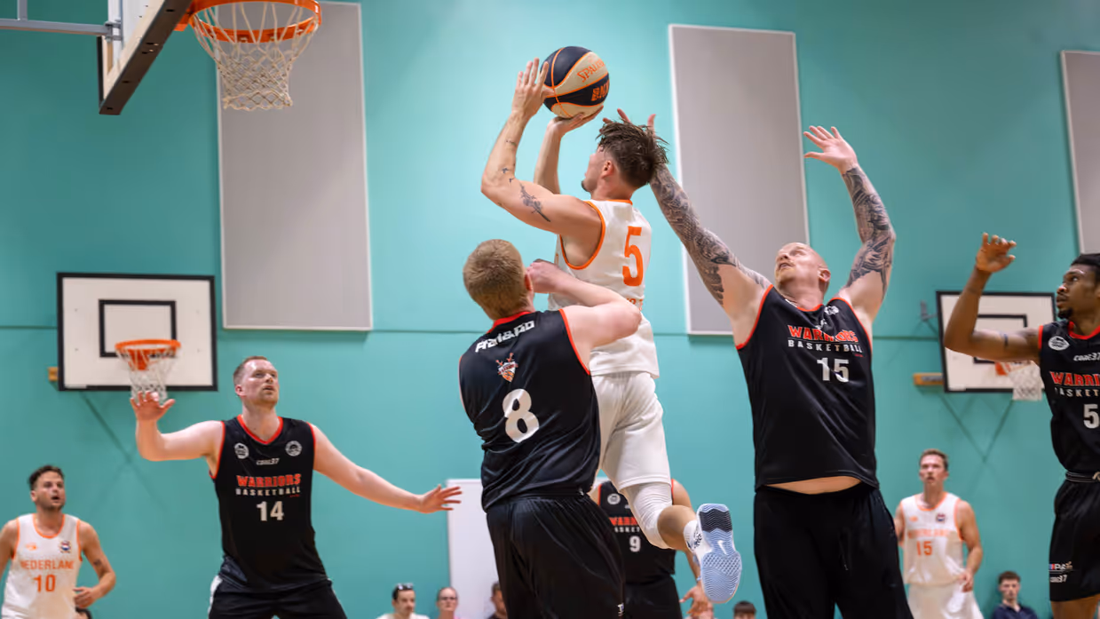 Marinier probeert te scoren tijdens basketbalwedstrijd.