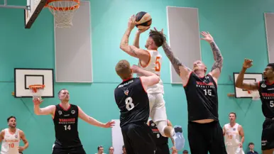 Marinier probeert te scoren tijdens basketbalwedstrijd.