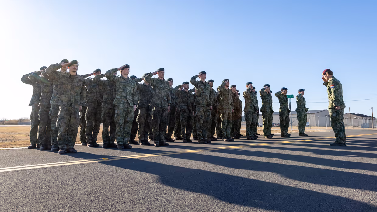  Dienjaarmilitairen in de houding voor hun commandant.