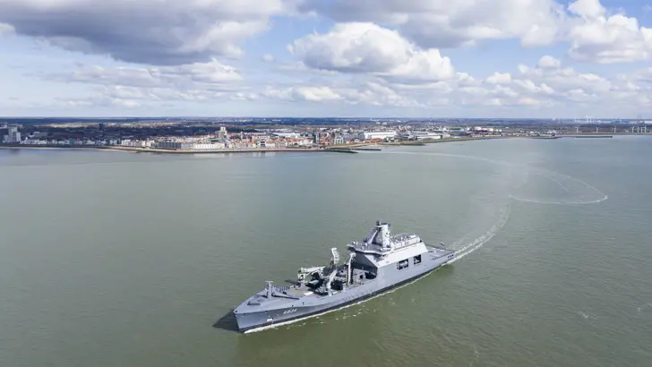 Zr.Ms. vaart weg van een stad.