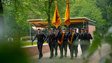 Adjudant Cor Binsma loopt met het vaandel   De vaandels tijdens de herdenking 