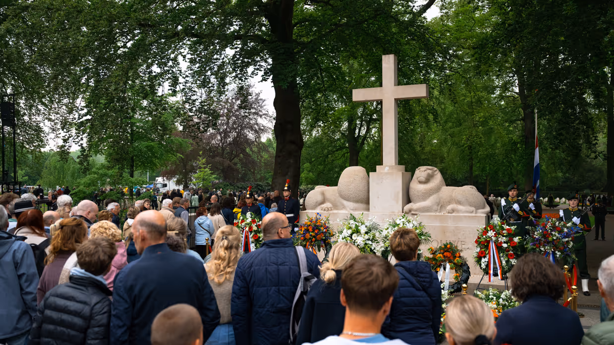 Publiek voor het Nationaal Monument op de Grebbeberg, waarvoor kransen staan en liggen. 