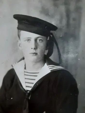 Zwart-wit foto van Dre Nagtegaal's opa als kind in een zwarte matroos uniform.