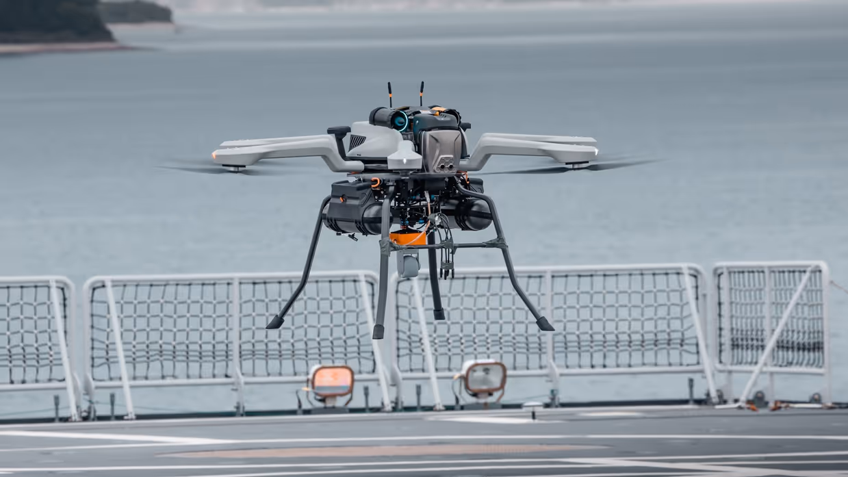 Een drone hangt boven een helidek.