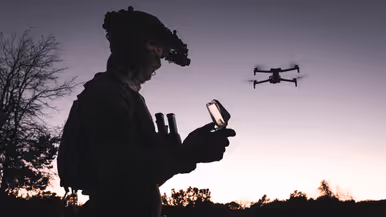 Een drone-operator bij zonsondergang.