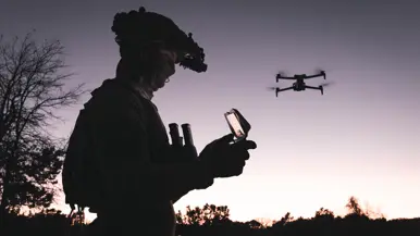 Een drone-operator bij zonsondergang.