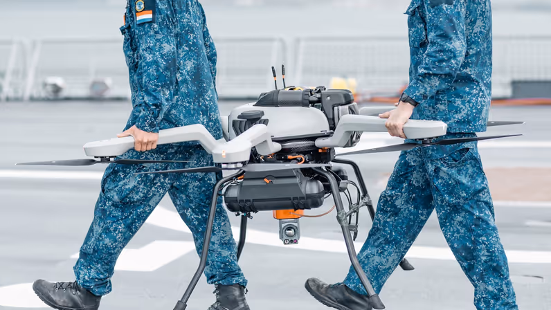 2 marinemensen lopen samen met een drone over het helidek van de Johan de Witt. 