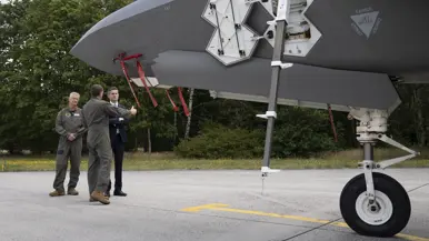 Berendsen op een platform vlak voor een F-35, waarvan het onderstel van de voorkant in beeld is. Een militair in vliegeroveral geeft uitleg. Naast Berendsen staat Commandant Air Combat Command commodore Marcel ‘Bo’ van Egmond.