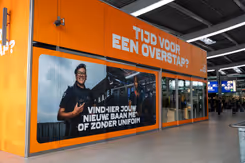 Oranje pop-up store met een foto van een vrouwelijke militair en de tekst: Tijd voor een overstap? 