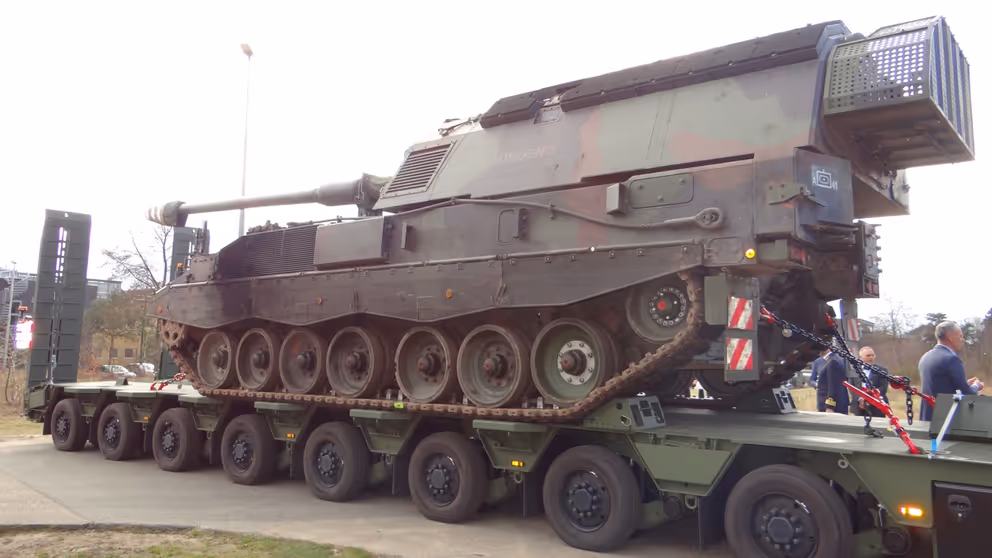 Een oplegger met daarop een pantserhouwitser geladen.