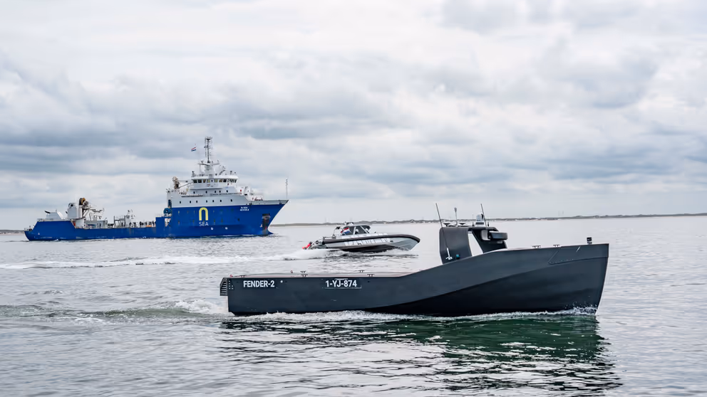 Een bemand en onbemand schip op open water.