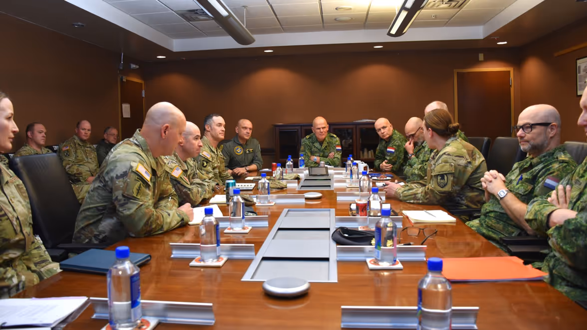 Militairen met elkaar in gesprek aan een tafel.